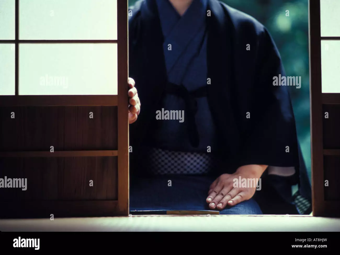 japanese-man-wearing-kimono-sitting-outside-tea-house-AT8HJW.webp